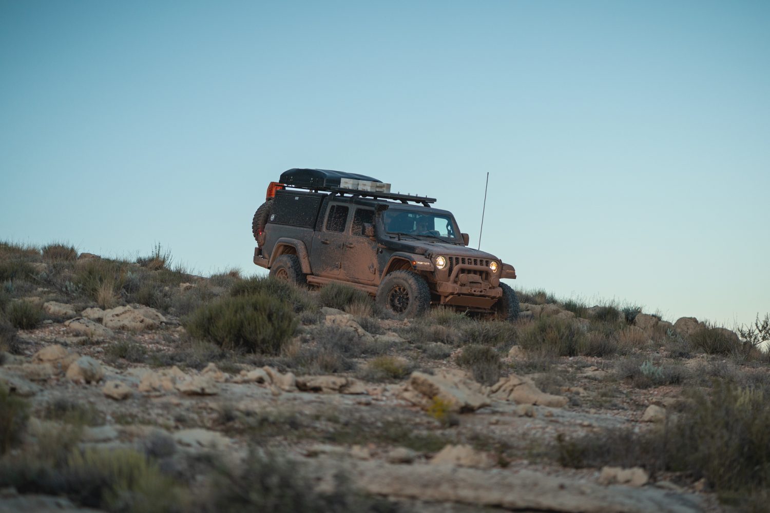 Built Jeep Gladiator driving through desert terrain.